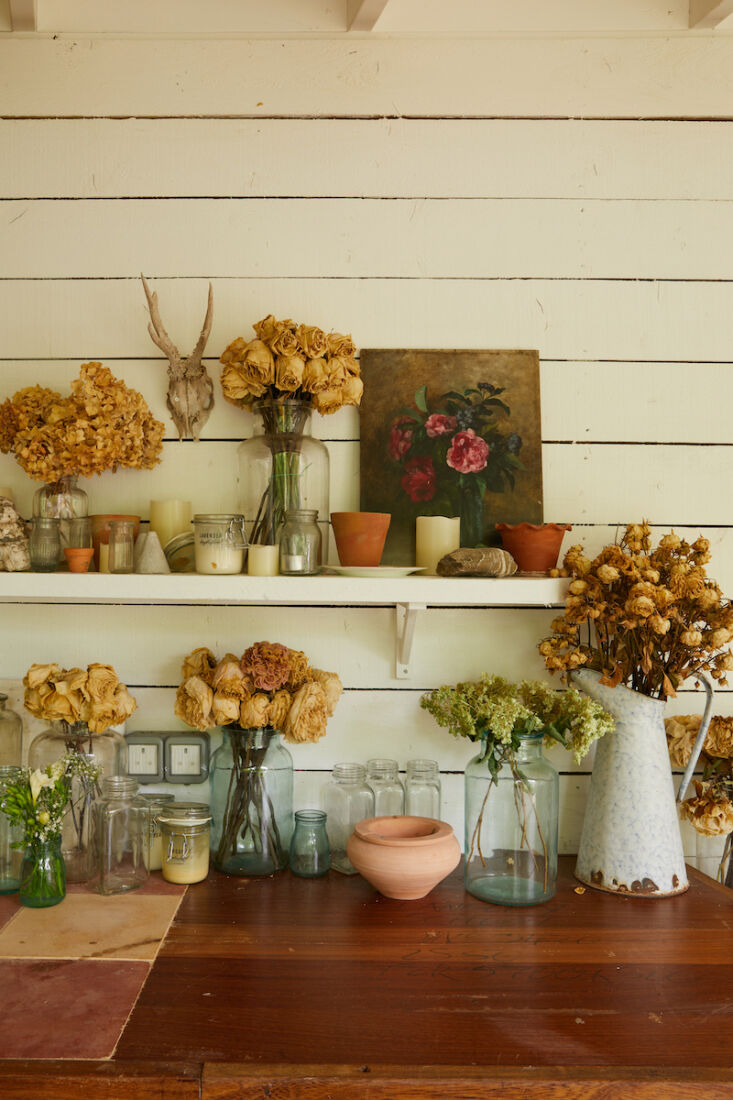 Vintage artworks and glass vases collected for and used on their wedding day line the kitchen walls.