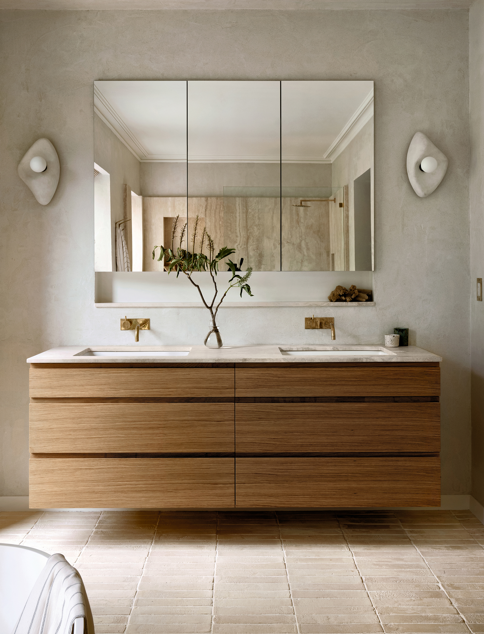 the custom wall mounted vanity is rift cut white oak with a navona travertine c 34