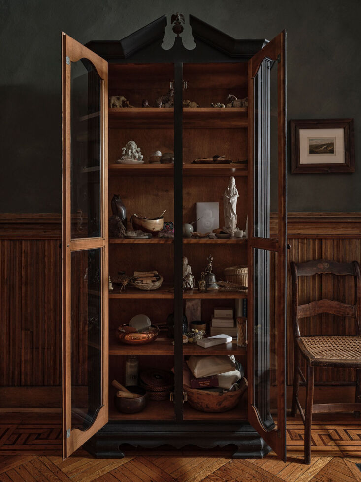 a glass fronted cabinet keeps curios. 25