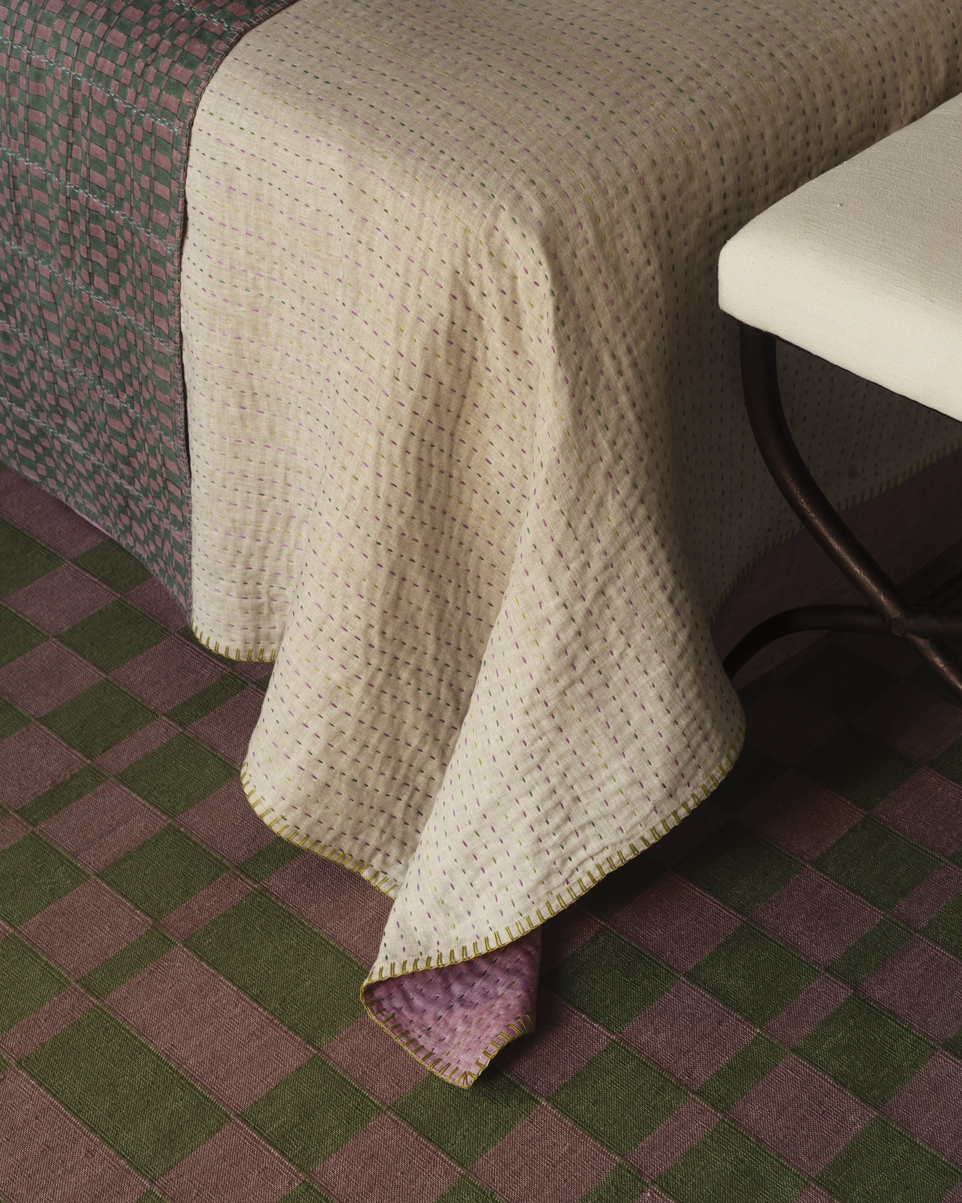 a hand embroidered quilt is layered with a throw made of  tilt two in alex 22