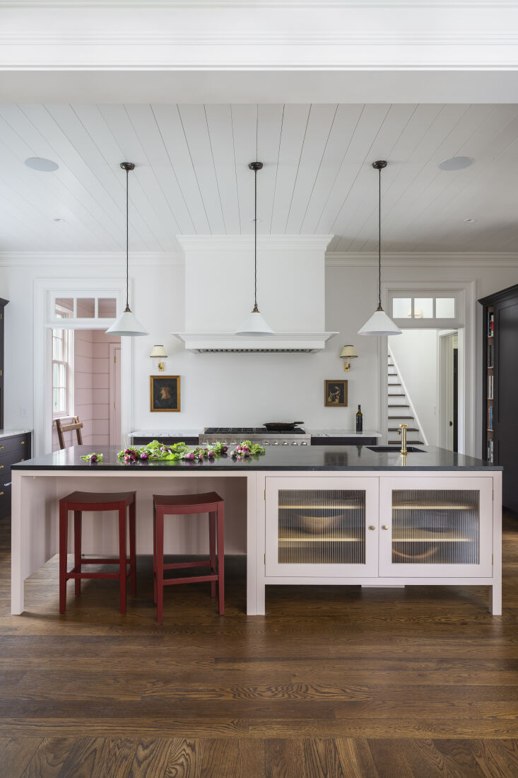 A soapstone countertop sits atop the light pink island, which serves as kitchen number 18.