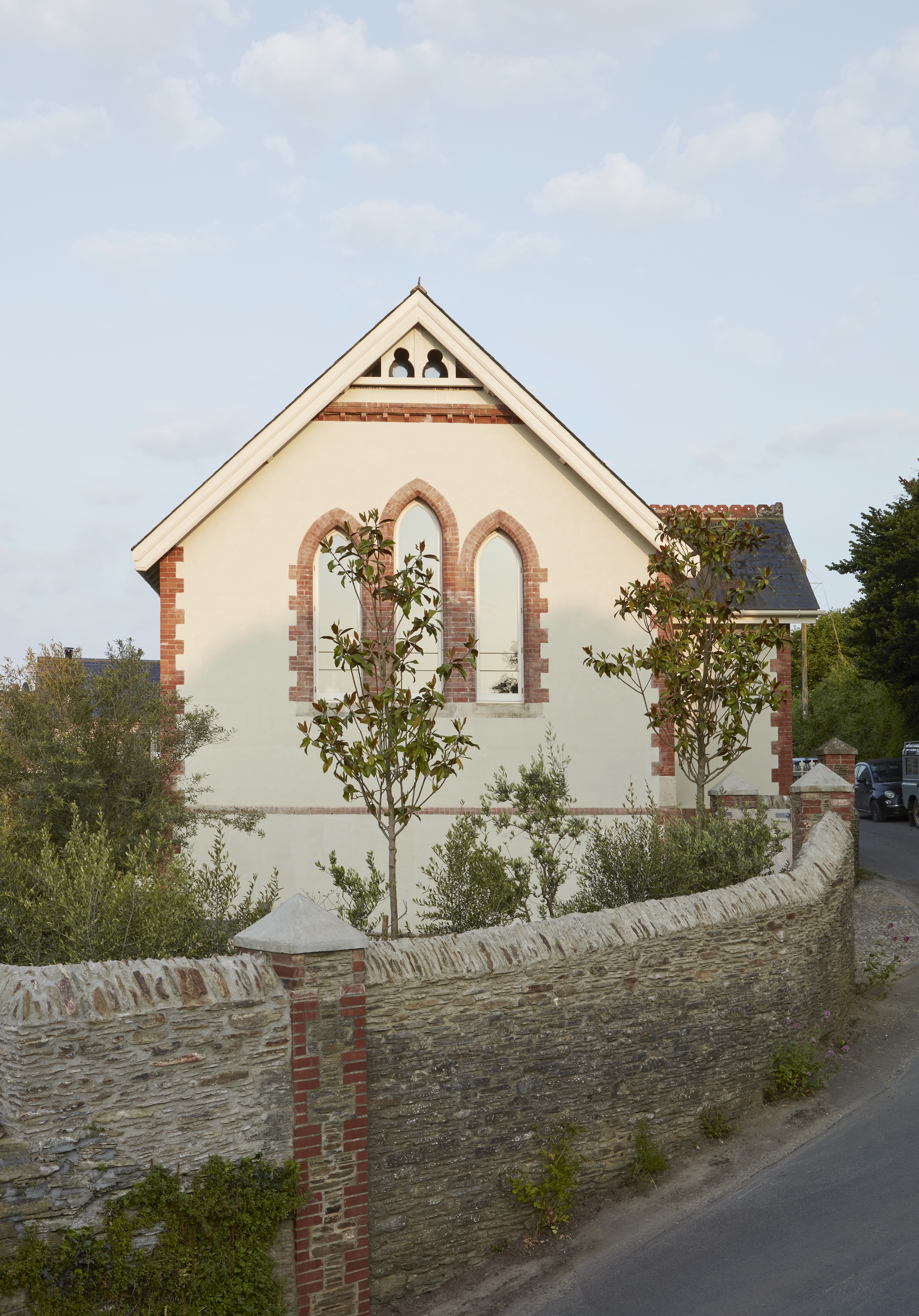 an old stone wall separates the brick and stucco chapel from the main road. 17