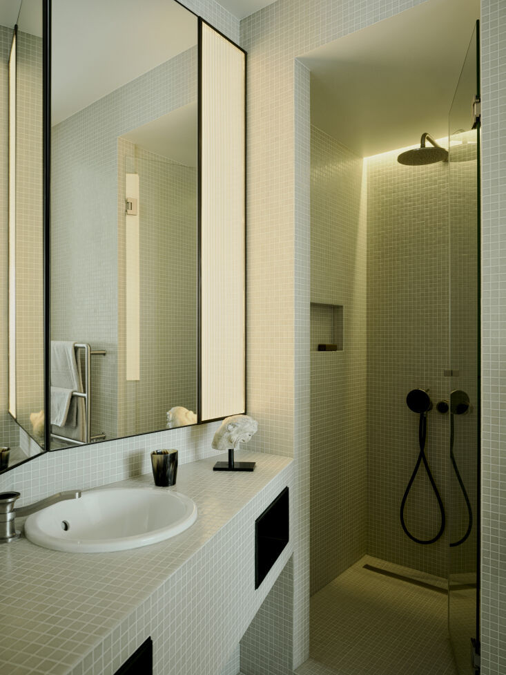 the bathroom is reminiscent of \1940s interior design with pale green glass mos 27