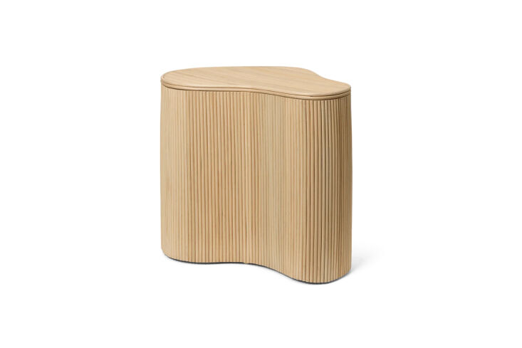 the ferm living isola storage table in natural has a lid that lifts to reveal a 23