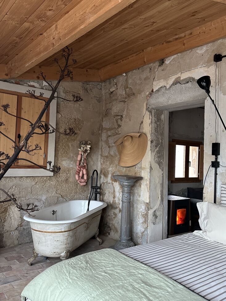 an antique bathtub with a refinished interior stands alongside the bed, and the 23