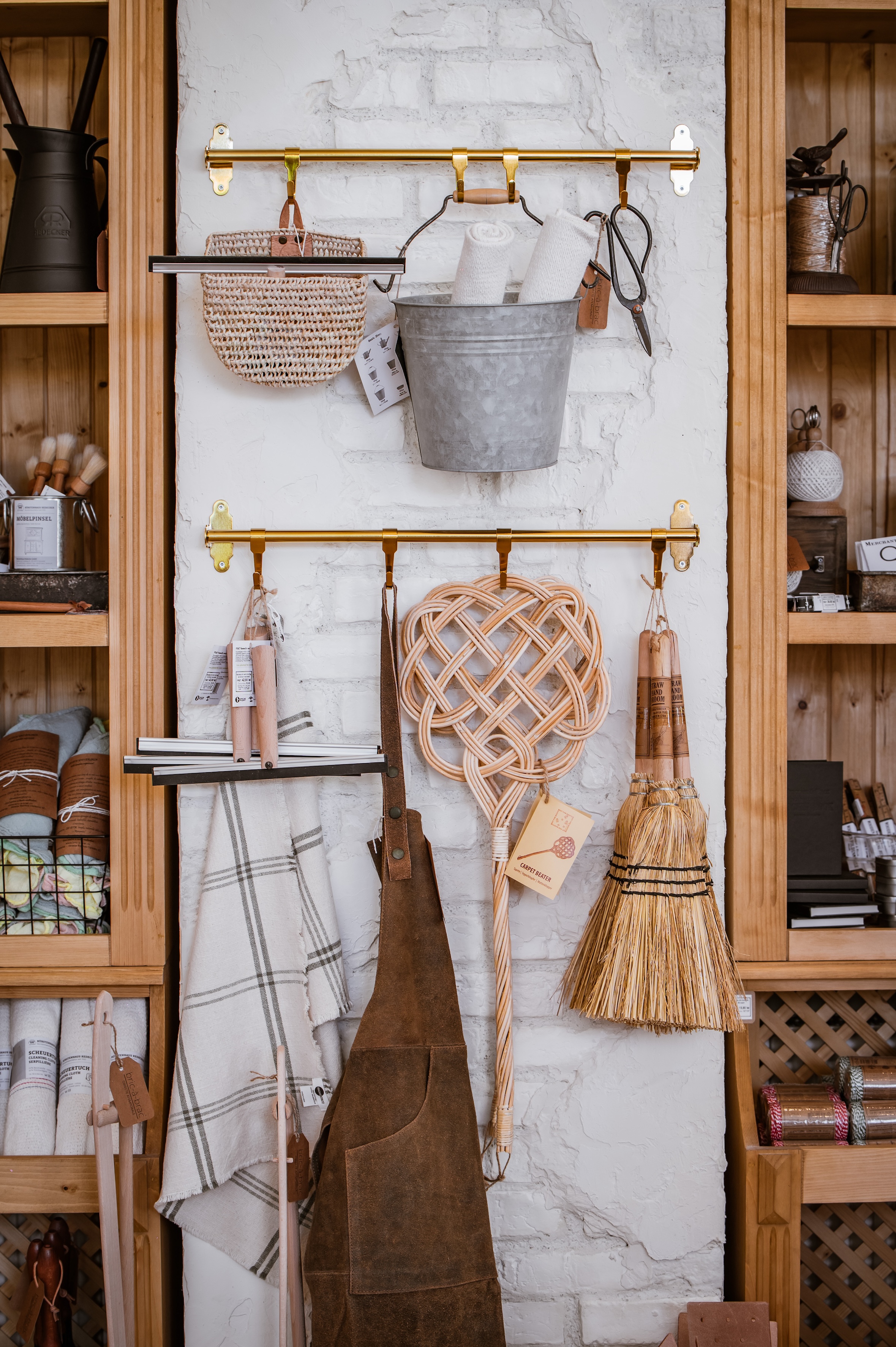 a hungarian leather apron hangs alongside wood handled squeegees and rattan car 19