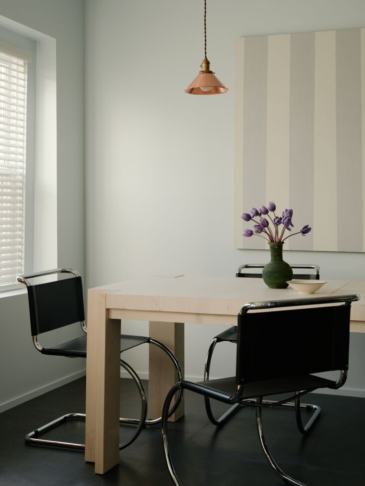 the adjacent dining area speaks to the metal clad kitchen with chrome and black 31