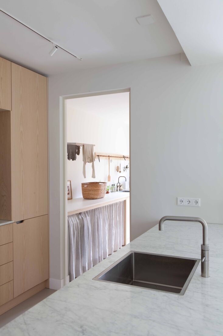 the kitchen opens to a utility room with a washing machine and dryer concealed  21