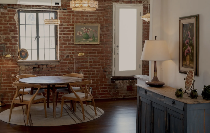 the dining area in the vitorrja apartment features an exposed brick wall, a les 34