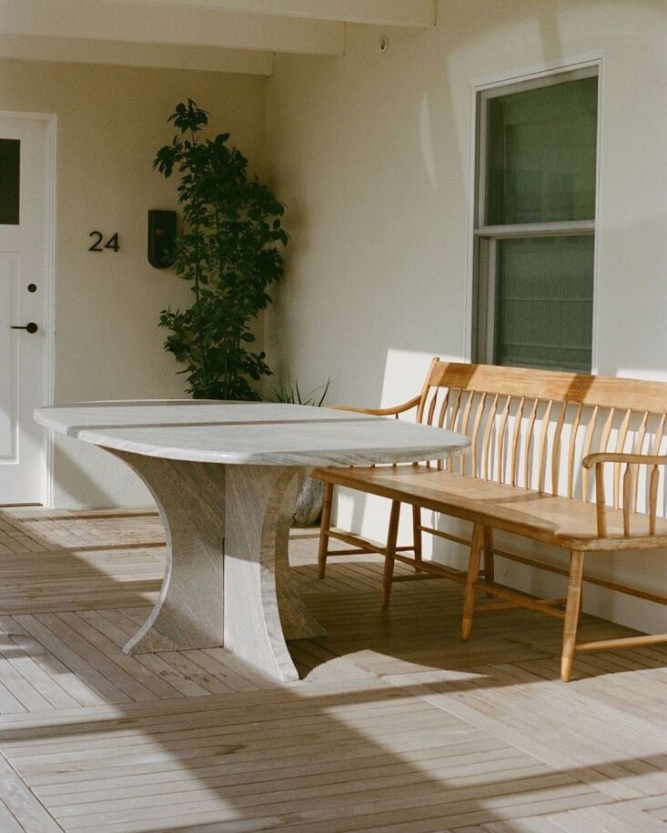 an outdoor seating area complete with custom bench and stone table outside room 28