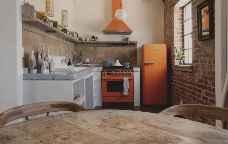 in the gjusta apartment, the kitchen has standout orange smeg large appliances. 33