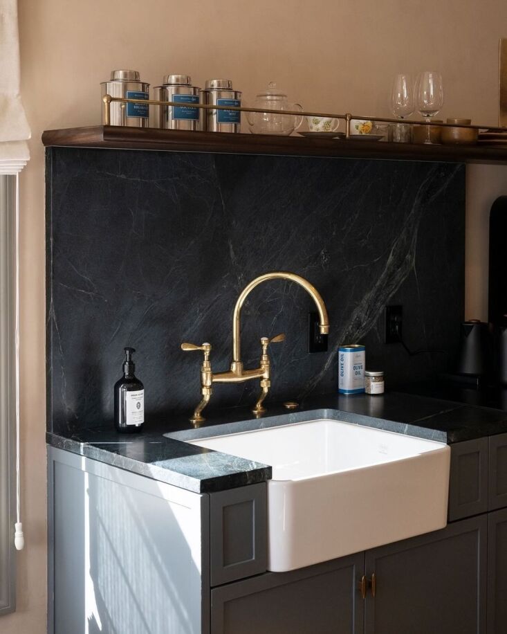 a kitchenette complete with apron front sink, brass bridge faucet, and the basi 21