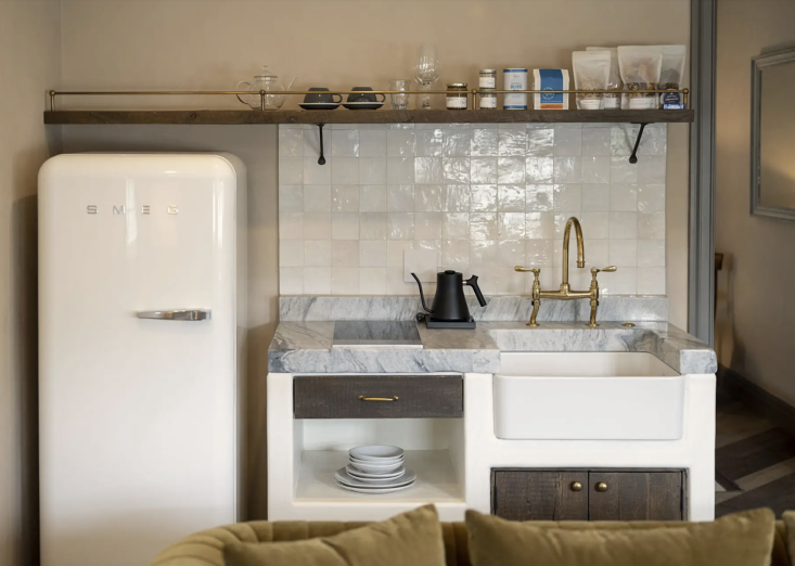 a kitchenette designed in plaster with walnut details, thick marble countertops 31