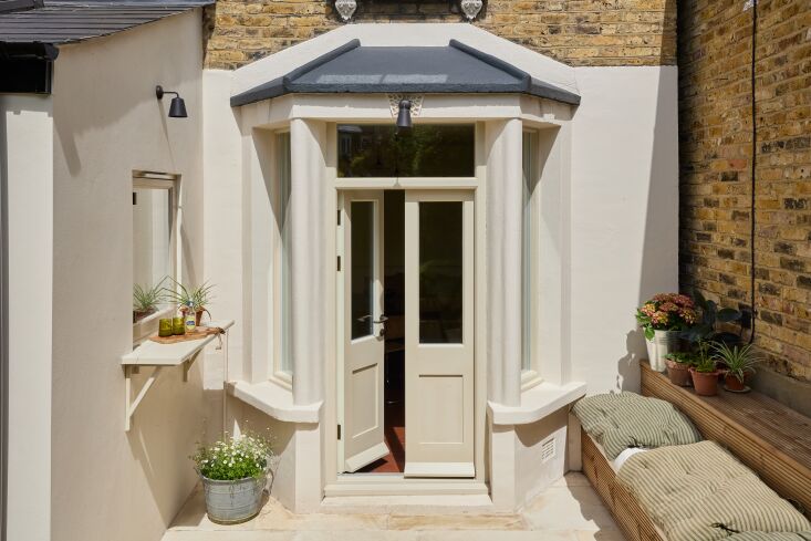 the refreshed victorian bay door leads to the garden, where laura designed a li 23