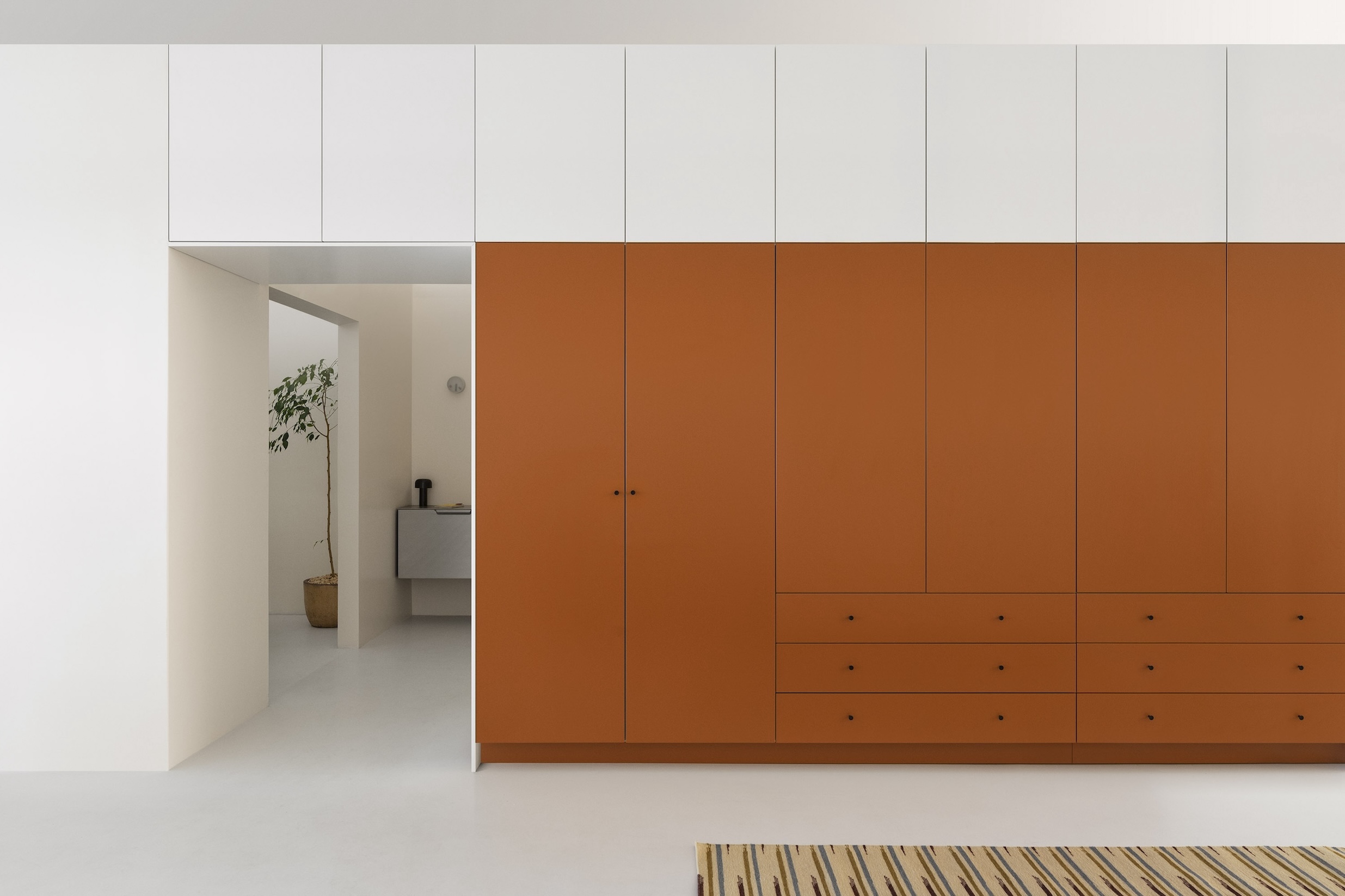 a wardrobe from the flat fronted plain collection frames a doorway. dusty orang 22