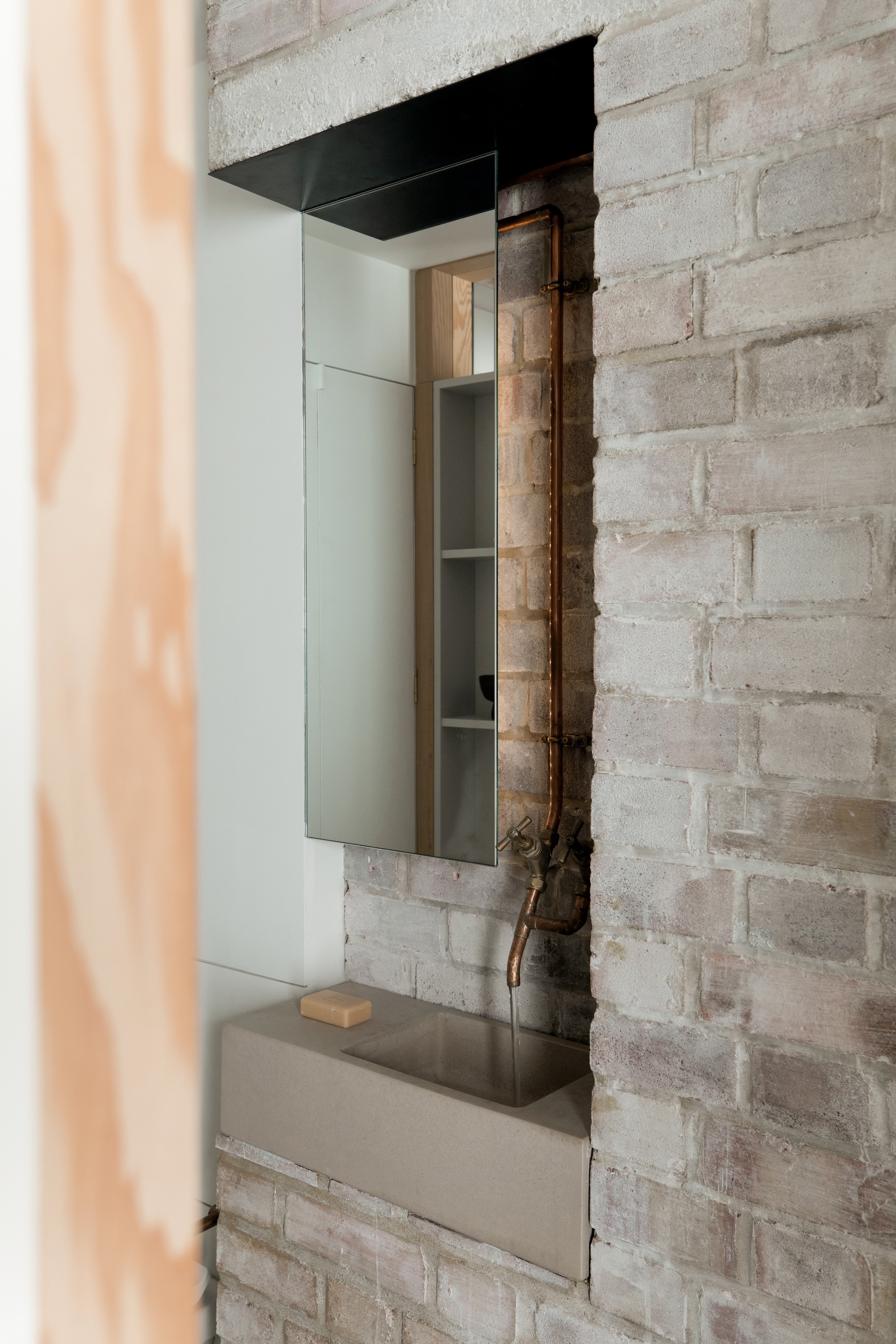 next to the kitchen, the powder room sink is set in a recess in the base of the 26