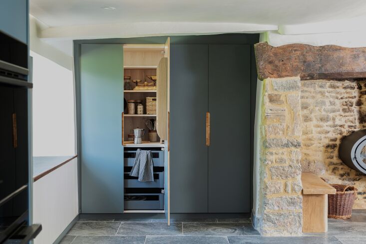 on the opposite wall, a deep custom larder provides much needed storage for dry 22