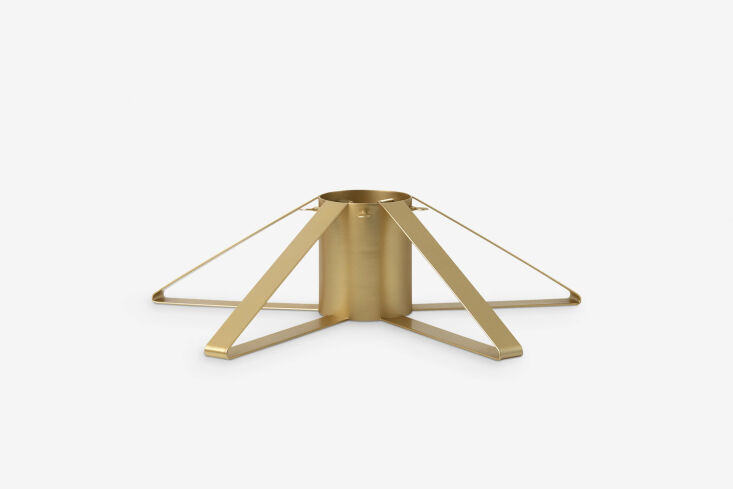 the ferm living christmas tree foot comes in brass (shown), gray, and black; \$ 19