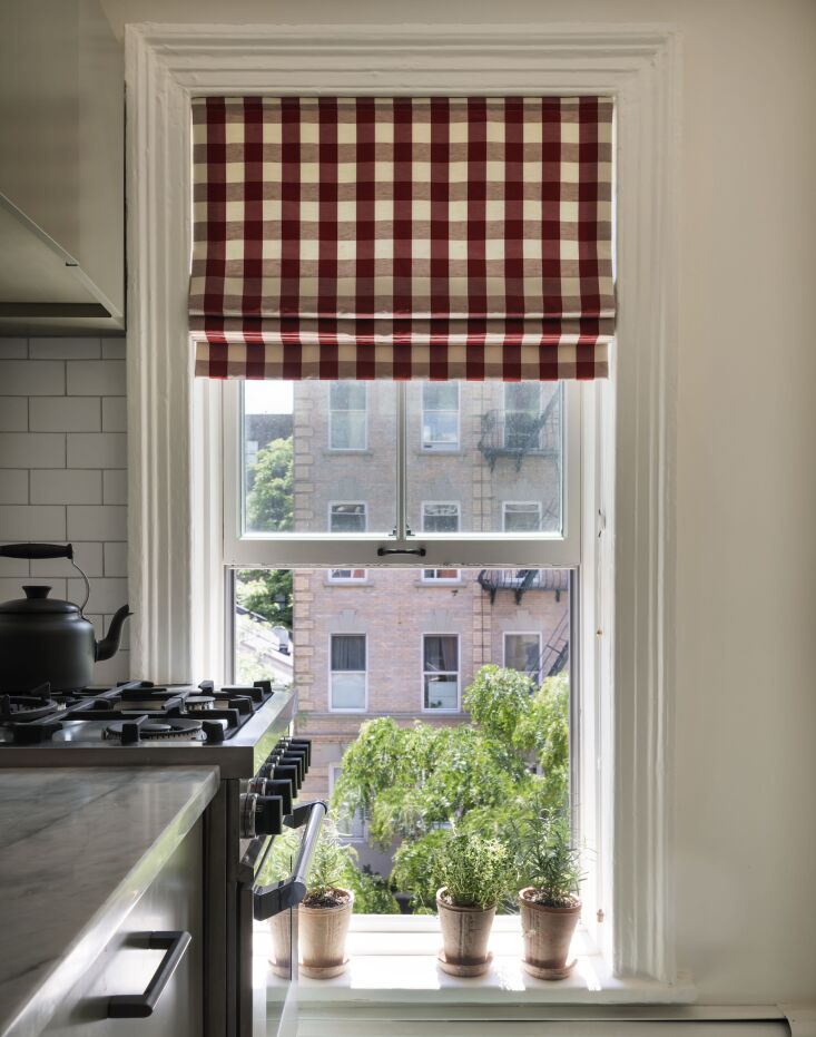 the apartment has floor to ceiling sash windows. red and white gingham curtains 19